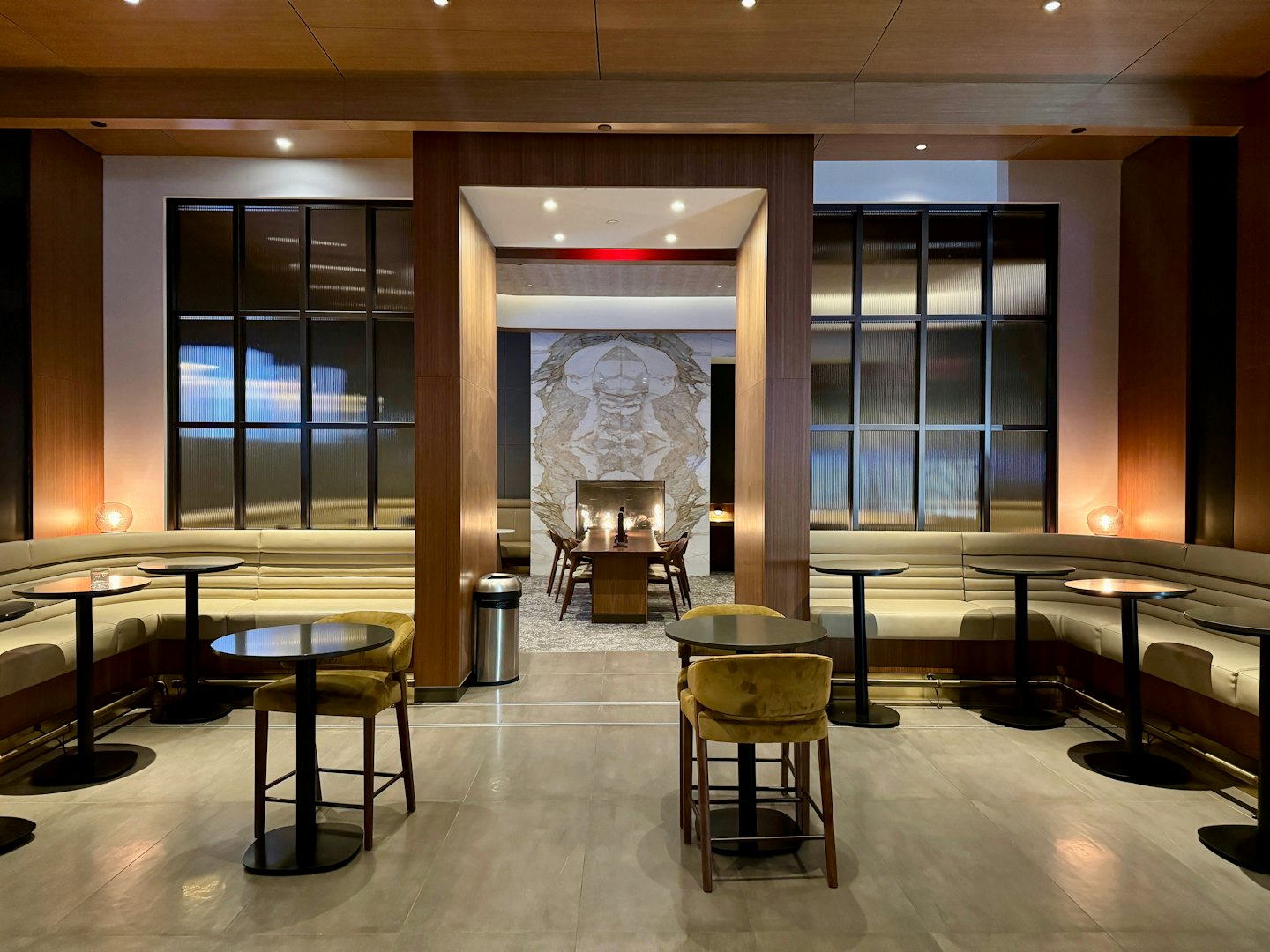 Modern lounge with banquette seating and marble wall detail.