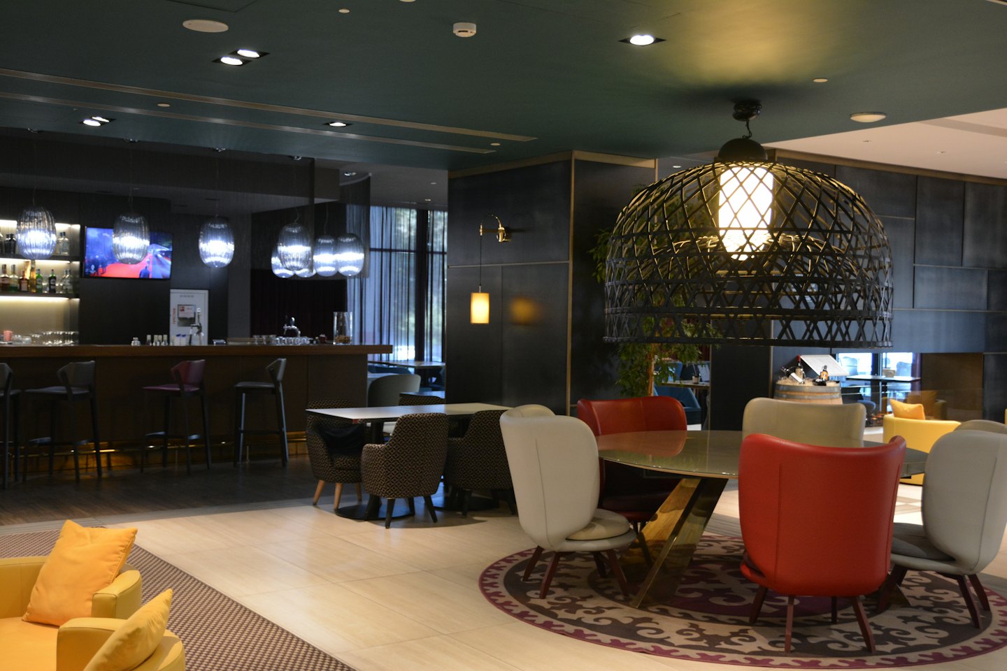 Modern bar and lounge with wooden bar and varied seating.